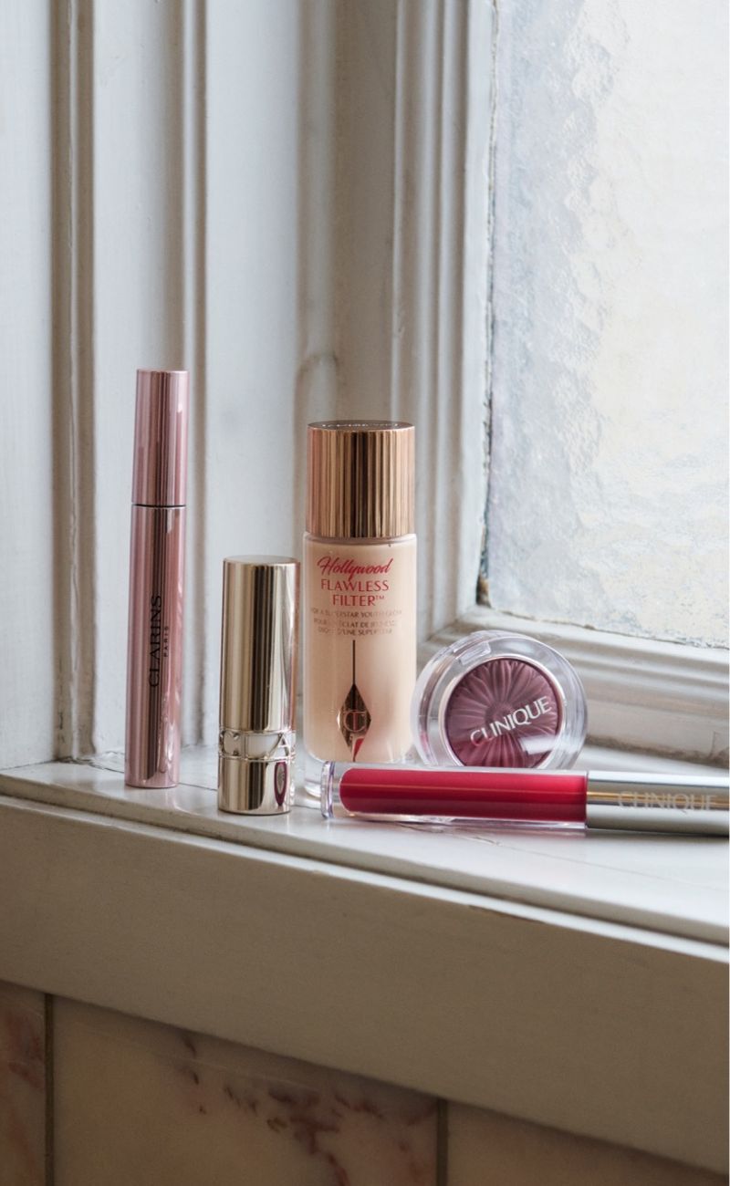 Gave indpakket i beige papir med brun sløjfe og beautyprodukter ved siden af