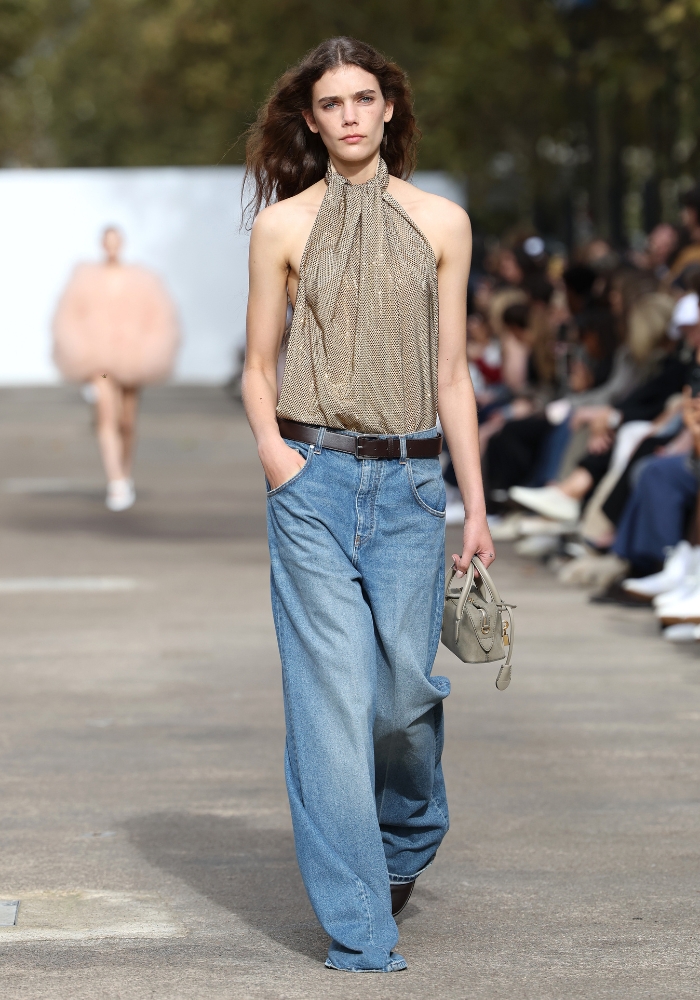 modell går på catwalken iklädd denim set