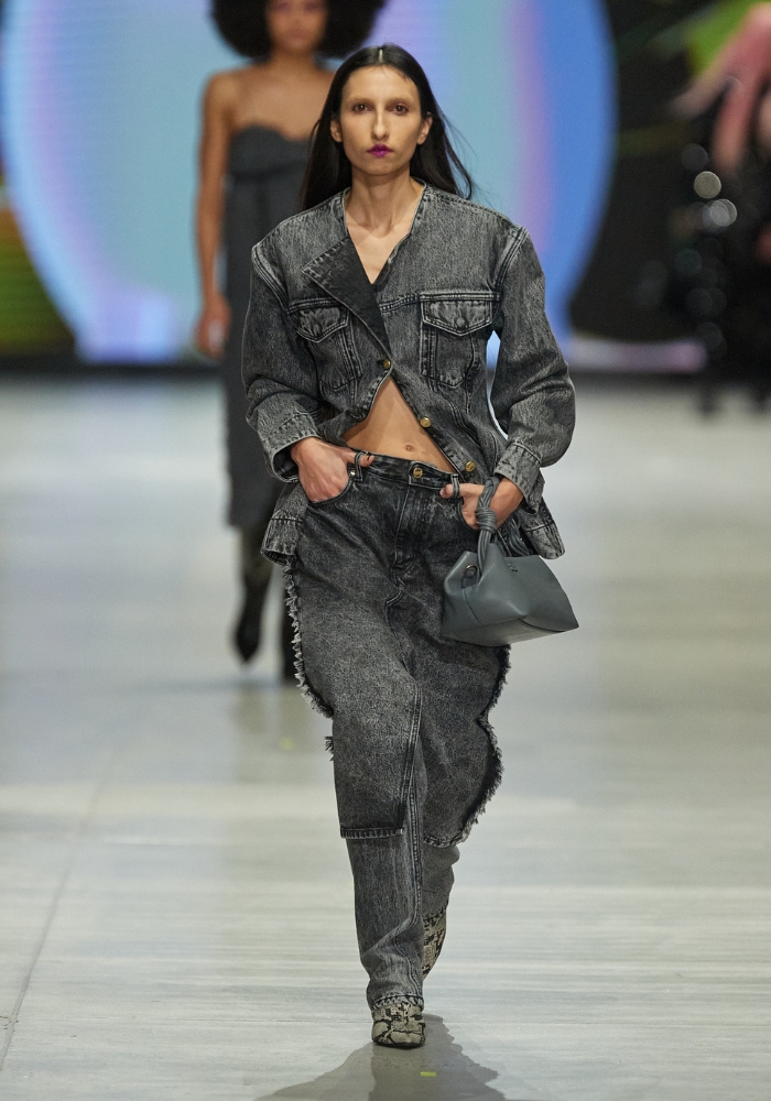modell går på catwalken iklädd denim set