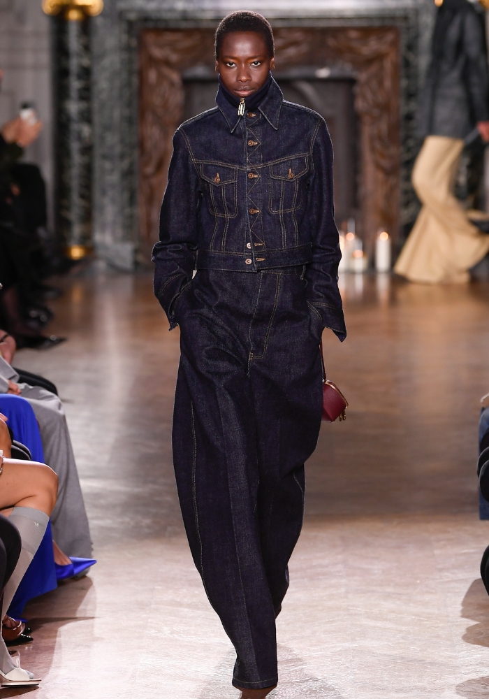 modell går på catwalken iklädd denim set